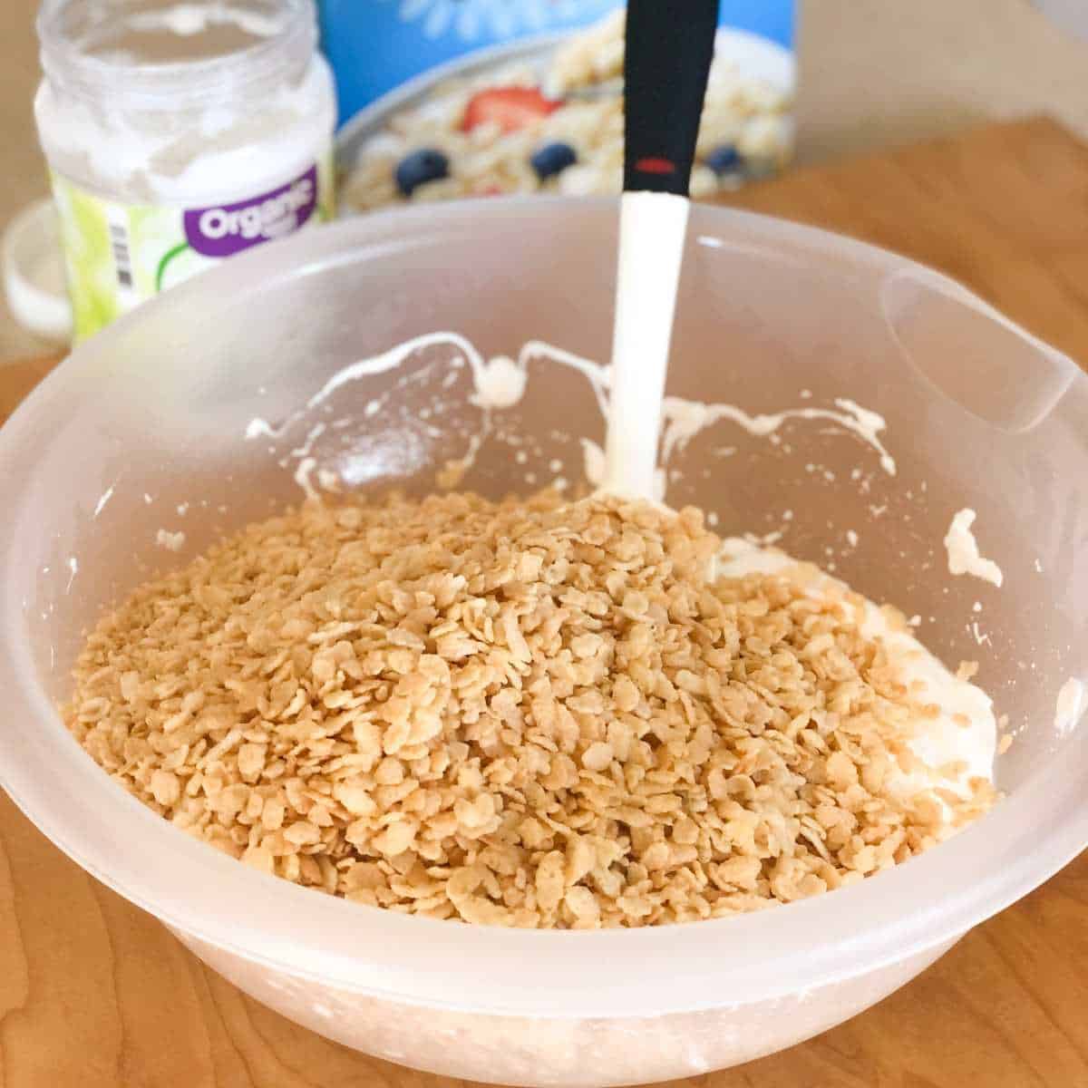 gluten free crispy rice being added to a bowl of melted marshmallows