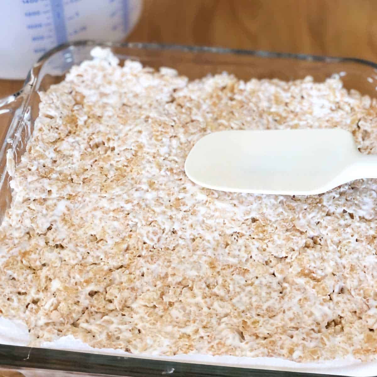 gluten and dairy free rice krispie and marshmallow mixture being formed into bars.