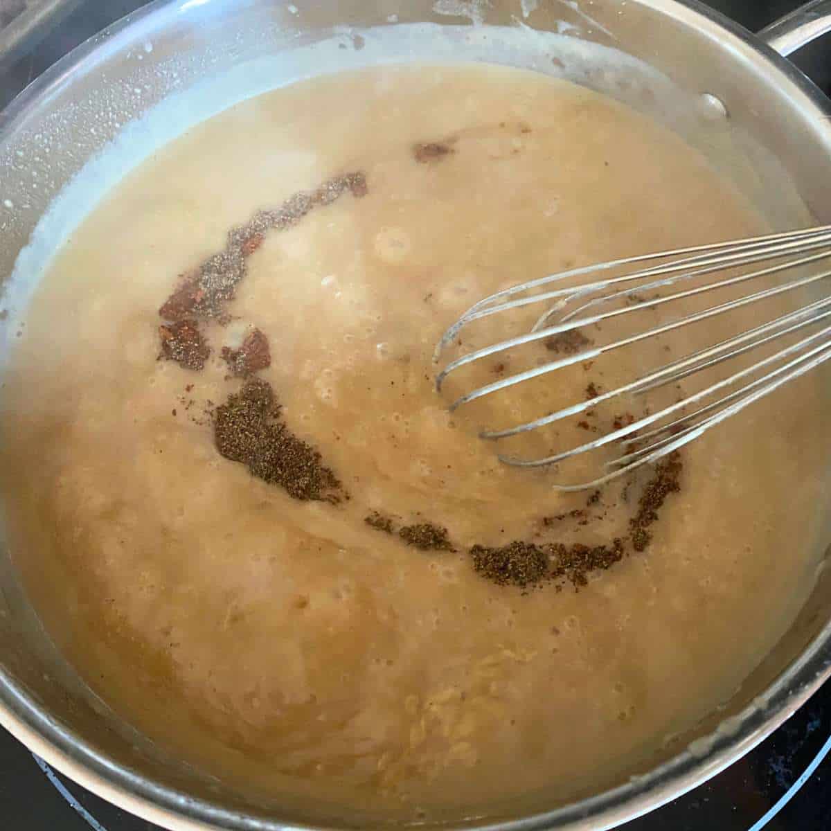 Spices being added to the meatball sauce.
