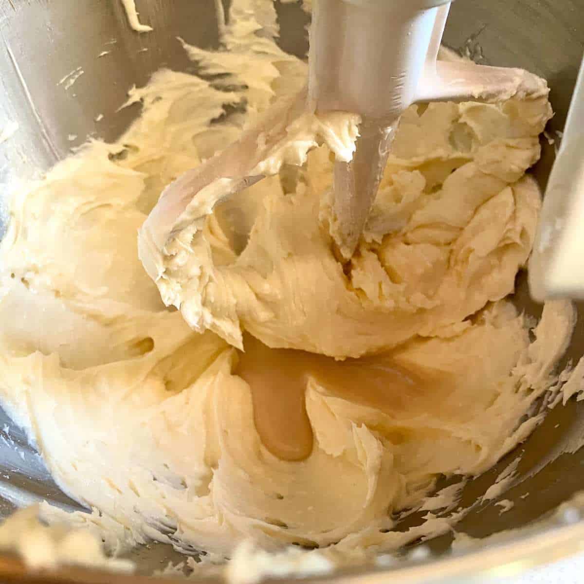Egg replacer mixture added to the margarine and sugar mixture in a mixing bowl.