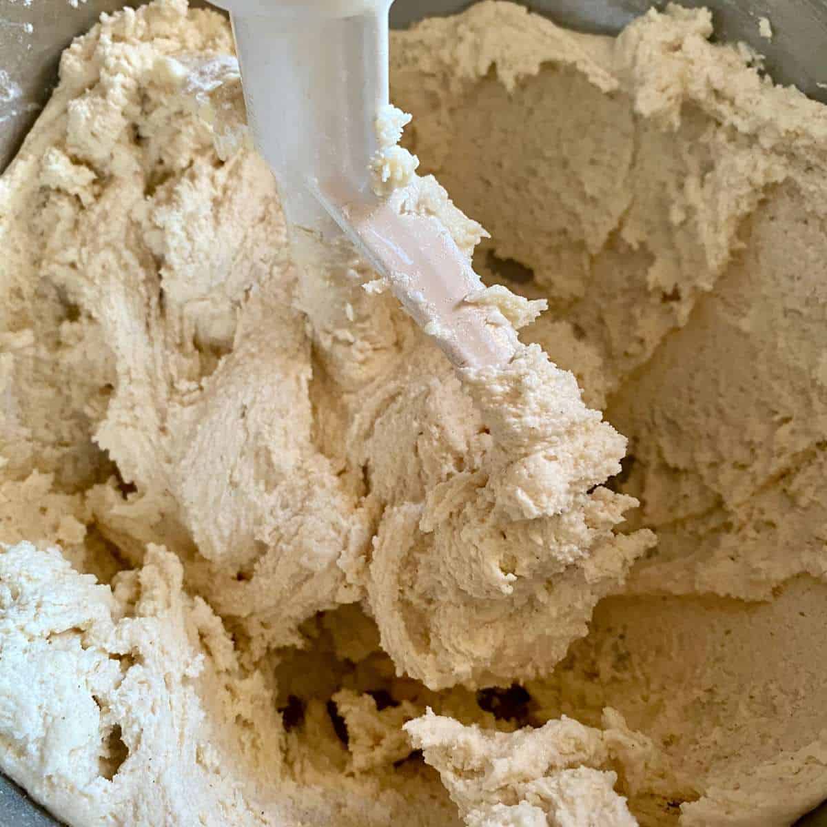 Gluten free flour being mixed into the dough with a mixer paddle.