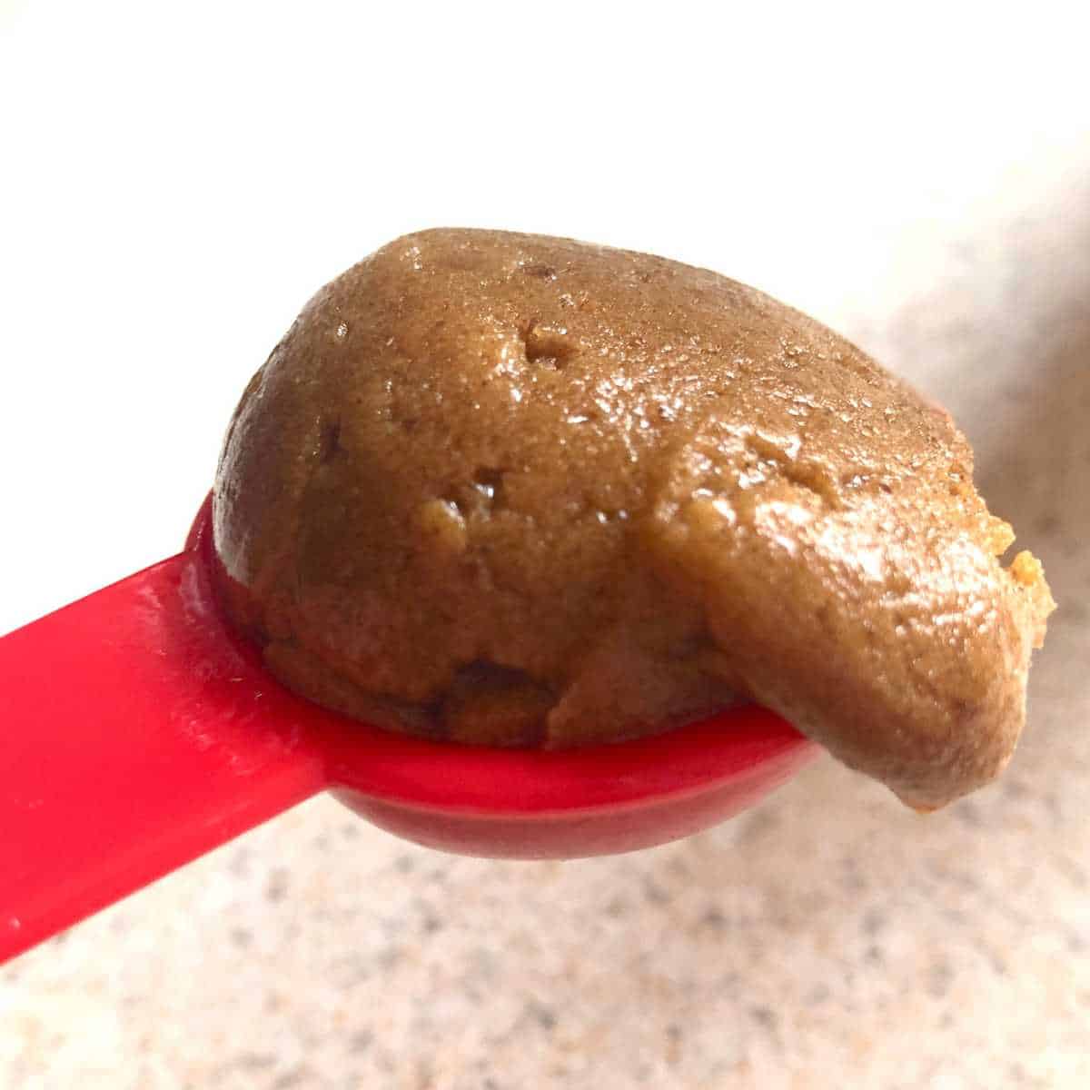 gluten free ginger cookie dough in a tablespoon measuring spoon