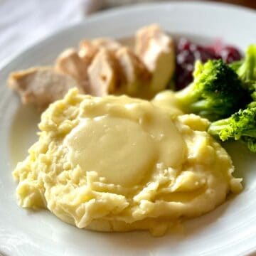 A serving of mashed potatoes topped with gluten free turkey gravy