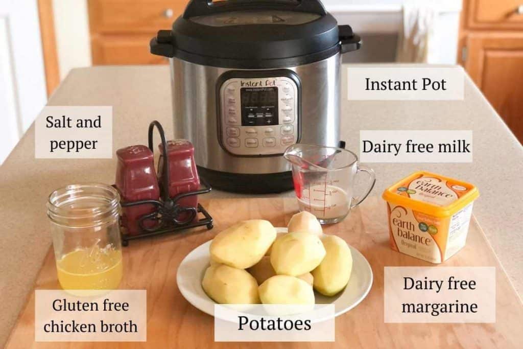 Ingredients needed for mashed potatoes including potatoes, broth, dairy free margarine and milk, and an Instant Pot