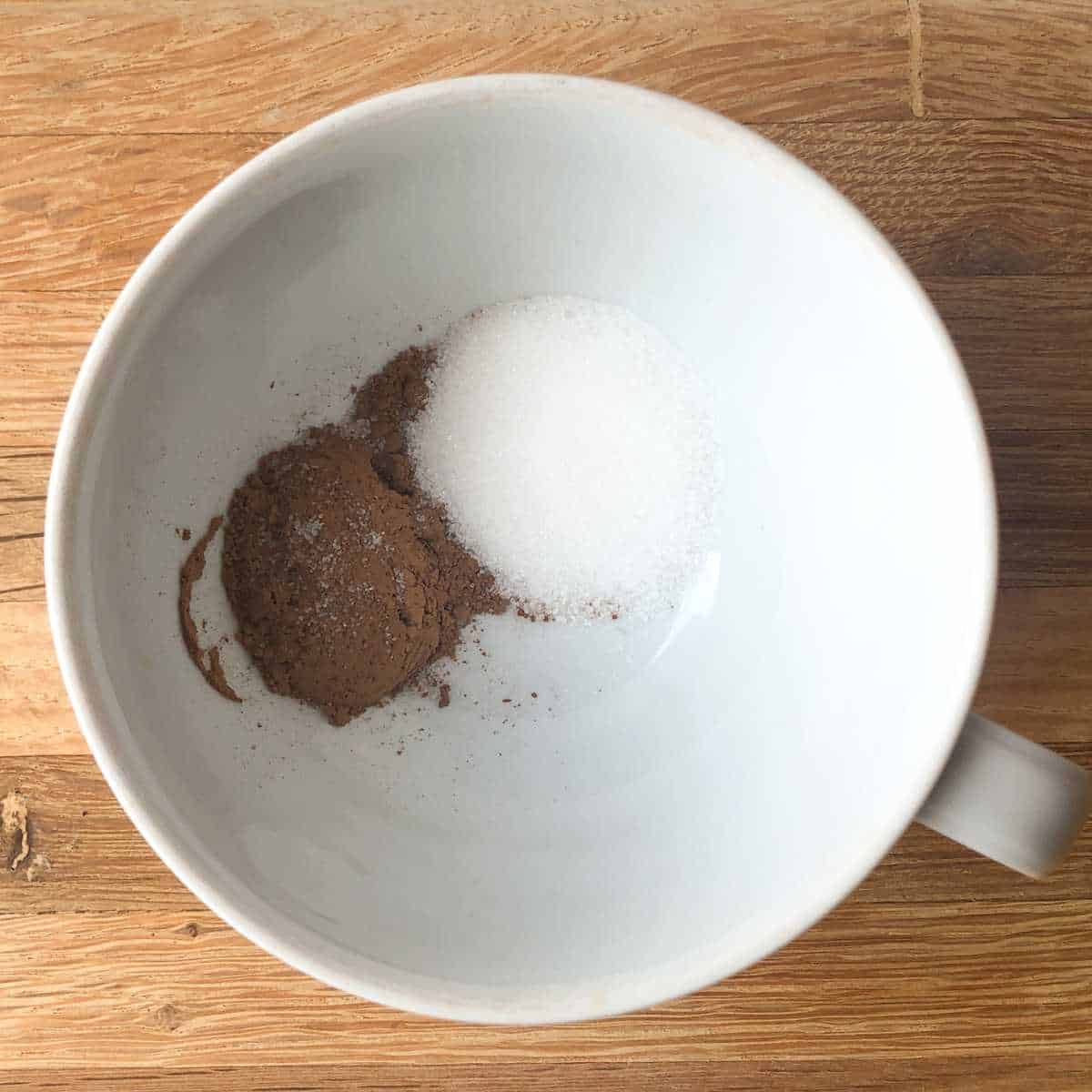 Cocoa powder, sugar, and salt in a mug.