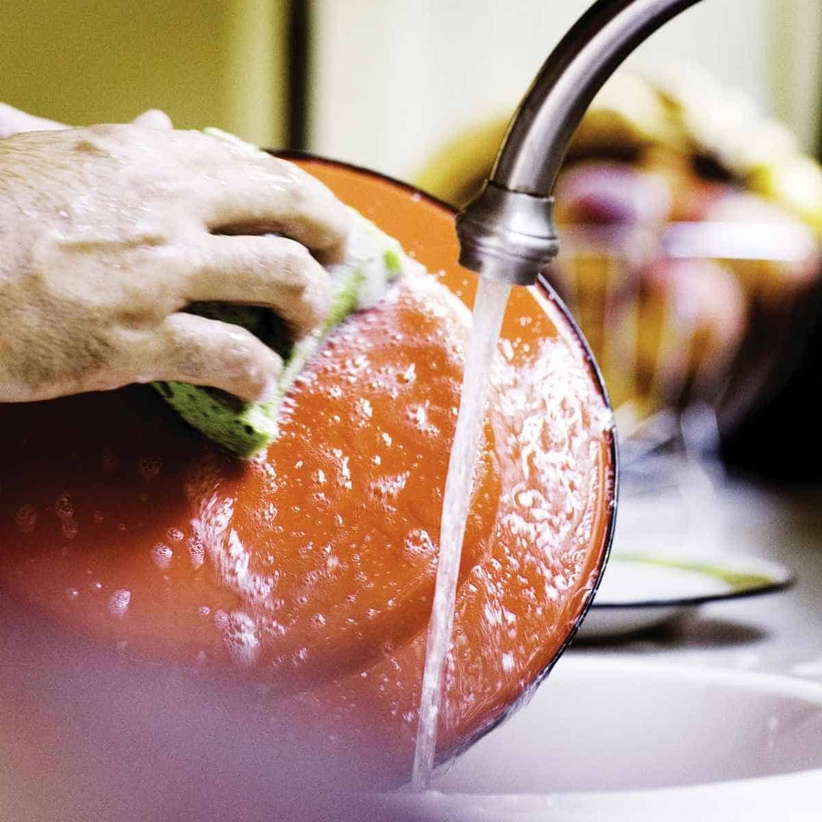 A dish being washed with soap and water to prevent cross contact