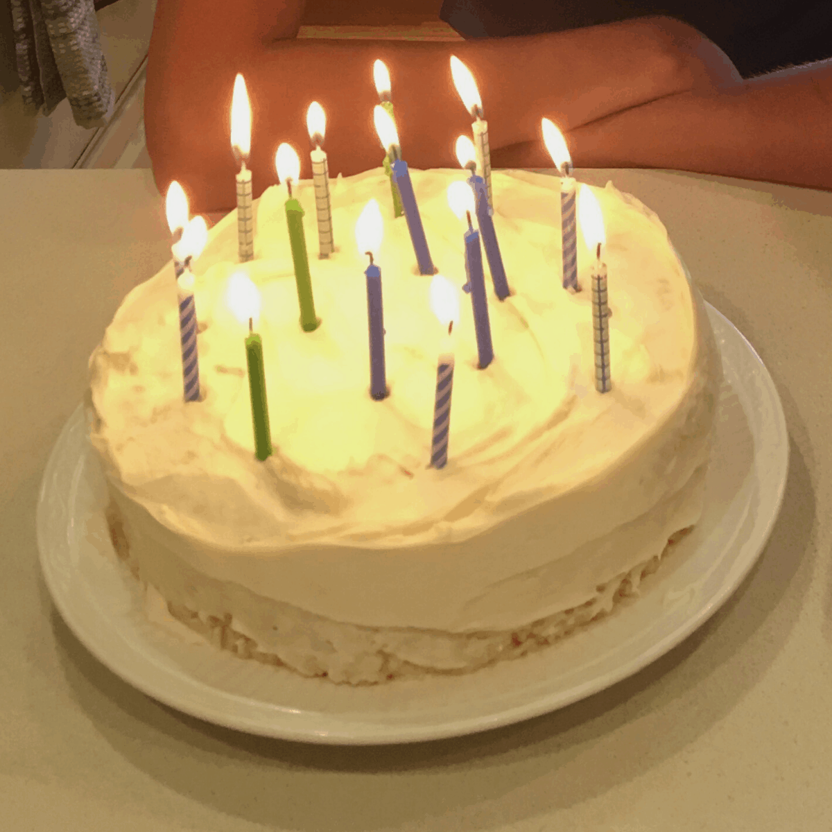 A birthday cake topped with lit candles made out of gluten and dairy free rice krispie bars.