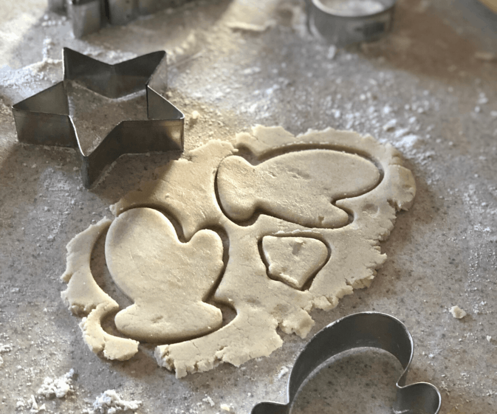 Two mitten-shaped gluten free cookie cutouts